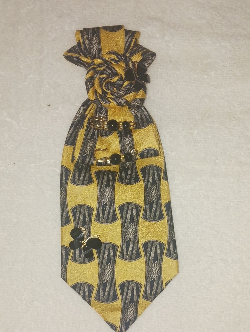 Gold and Black Patterned Men's Necktie with Decorative Pins.
